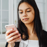 A teen girl looking at her phone
